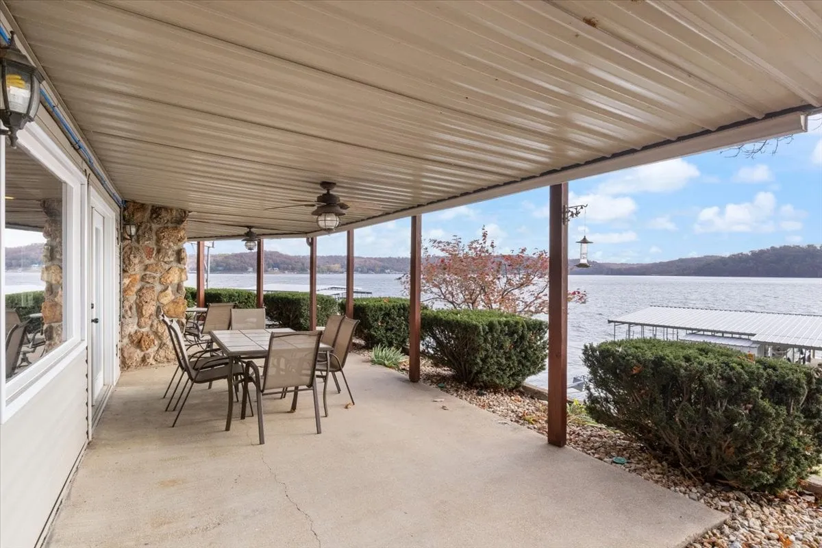 The image showcases an outdoor dining table and chairs set against a beautiful waterfront backdrop. The layout encourages group gatherings, outdoor meals, and social connection, echoing the section's emphasis on family, group activities, and relaxation. Landscaping with shrubs adds a touch of comfort and homeliness to the scene.